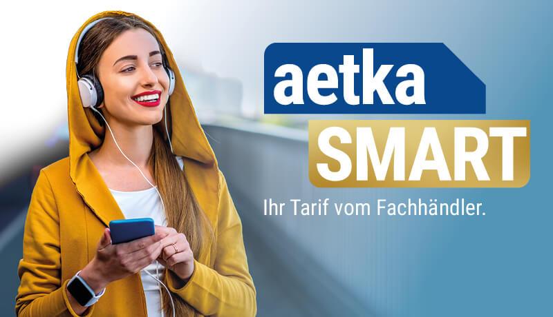 Frau mit Smartphone in der Hand nutzt den aetkaSMART Tarif