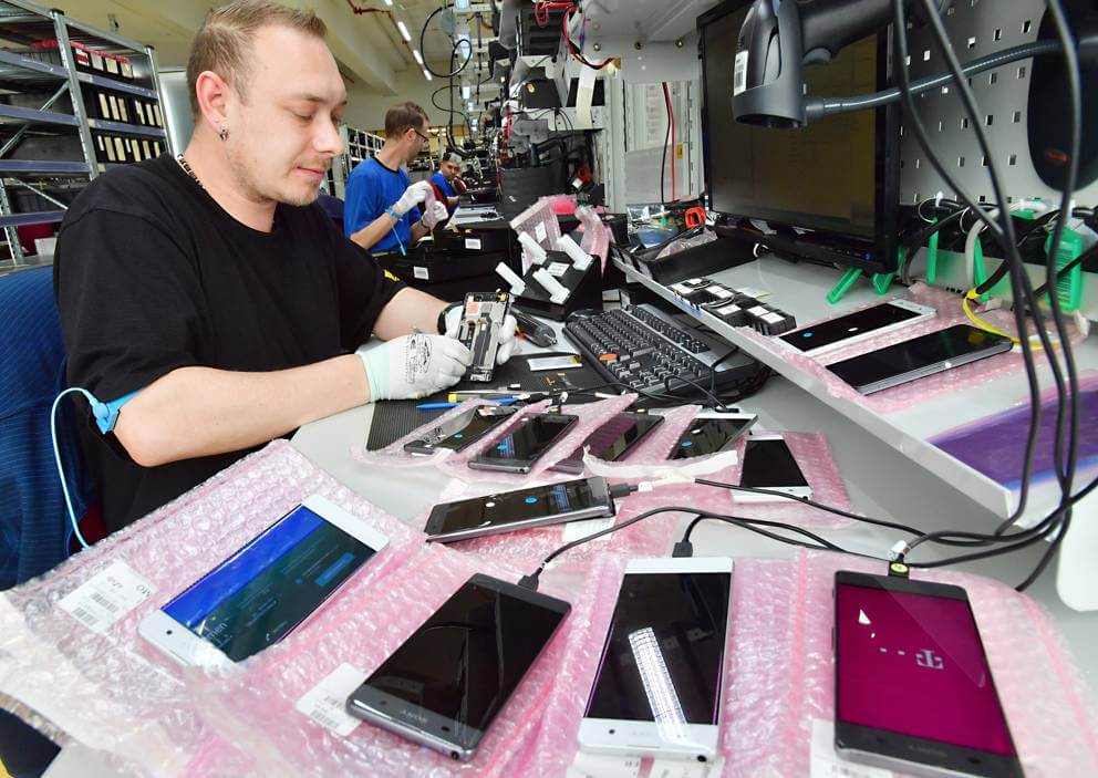 Mitarbeiter der aetka repariert Smartphones in der Reparaturwerkstatt