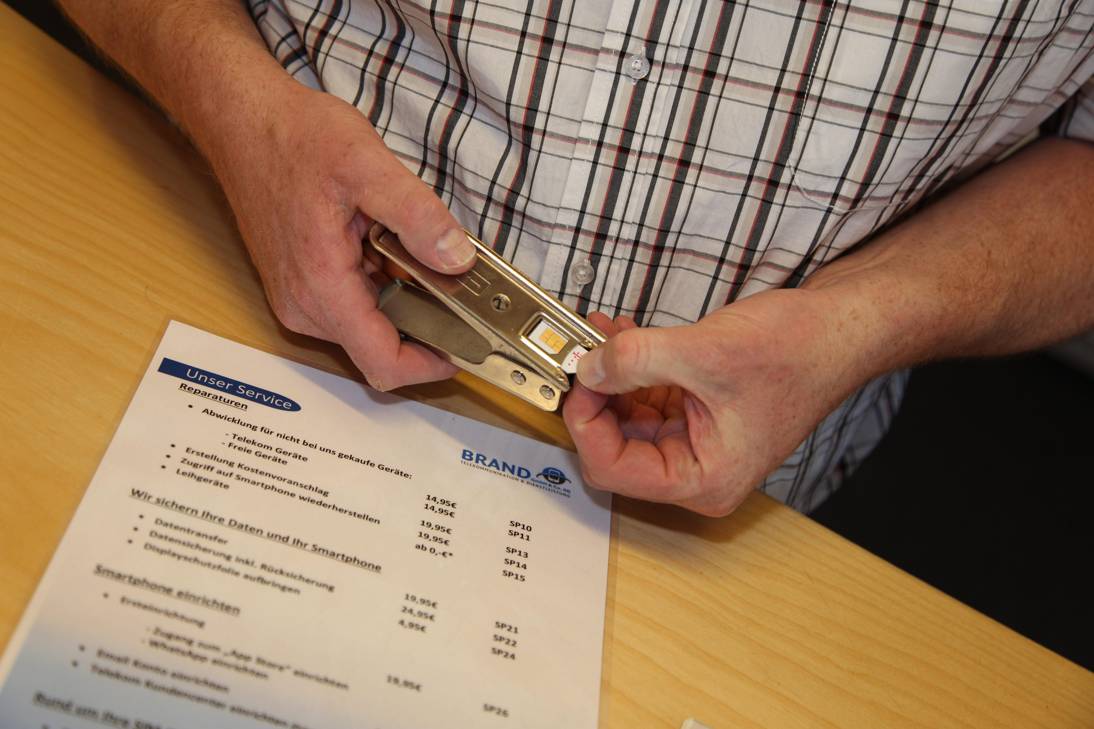 aetka Fachhändler stanzt eine SIM-Karte am Schreibtisch