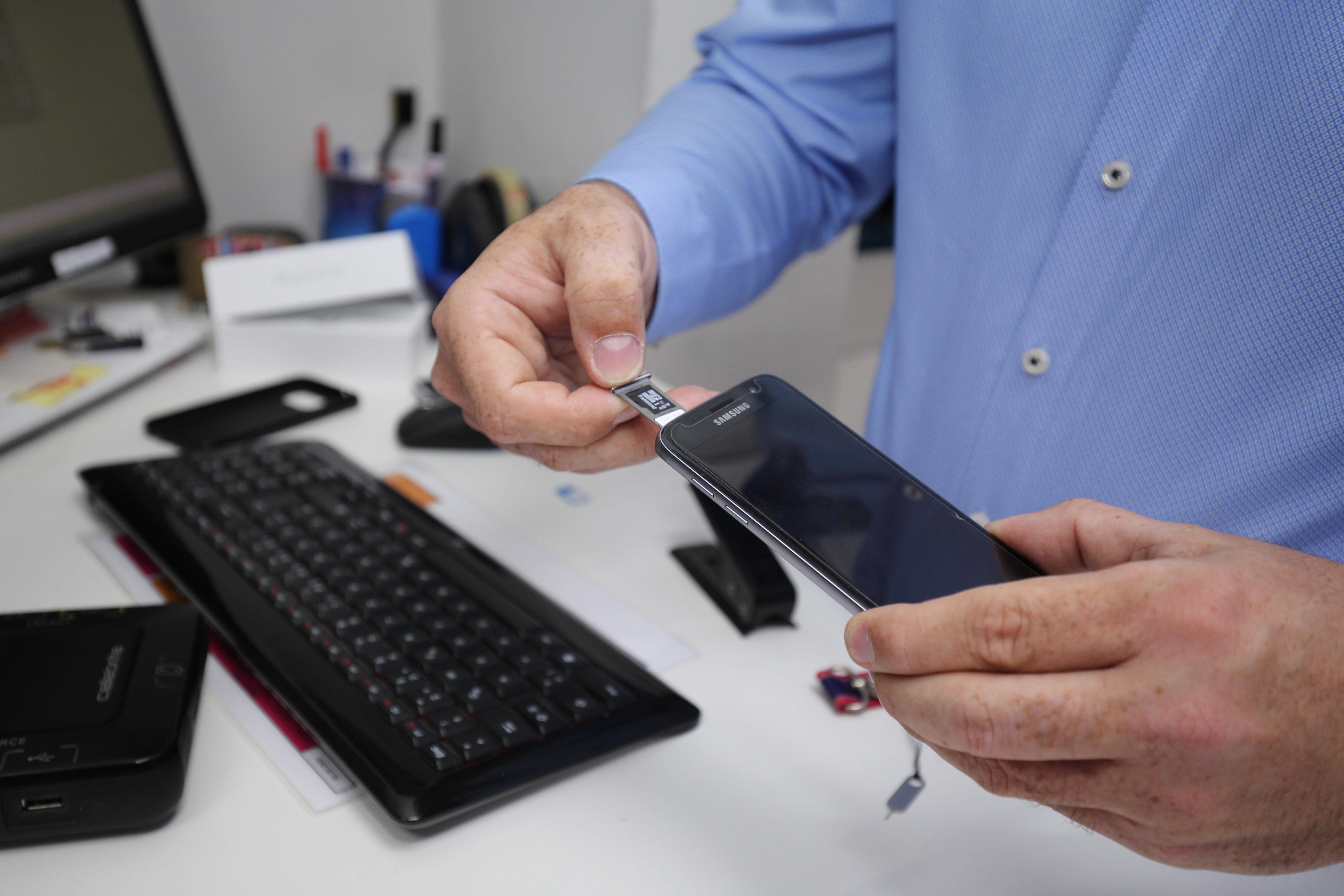 Mitarbeiter der aetka stanzt eine SIM-Karte