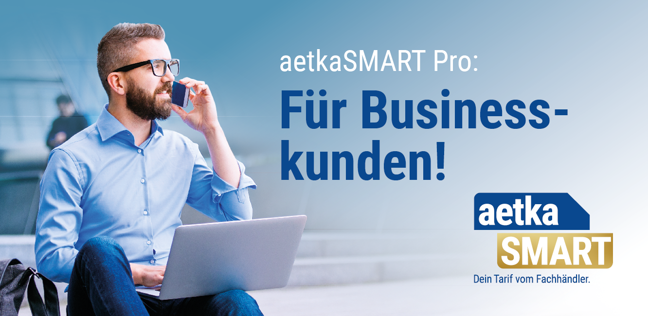 Geschäftsmann mit Hemd und Brille hat Laptop auf dem Schoß und telefoniert